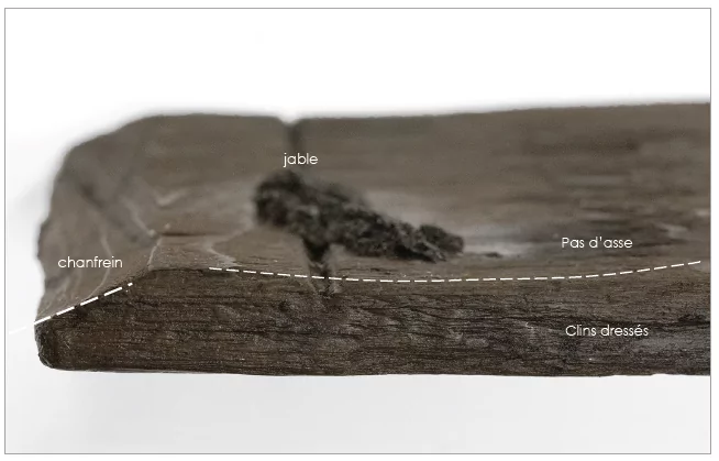 Détail d’une pièce de bois montrant le jable, le chanfrein et les traces de dressage